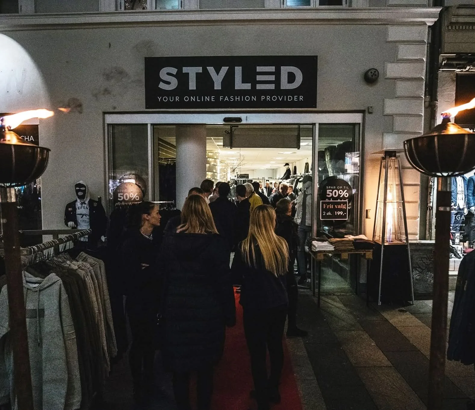 Historisk foto af Styled-butikkens facade med STYLED-skilt og personer ved indgangen.